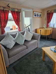 a living room with a couch and a table at Home from home 2 in Ingoldmells
