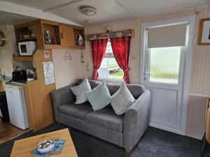 a living room with a couch and a window at Home from home 2 in Ingoldmells