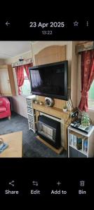 a living room with a flat screen tv on a table at Home from home 2 in Ingoldmells