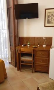 a desk in a room with a television on the wall at Casa Leone in Sciacca