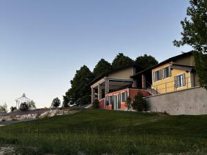 a house on a grassy hill with a water tower in the background at La Torre Granaia in Serravalle Scrivia +57 photos