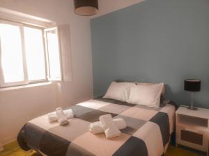 a bedroom with two beds with white towels on them at Casa do Mestre By Gt House in Évora
