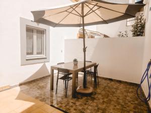 a table with an umbrella in a room at Casa do Mestre By Gt House in Évora