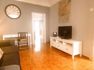 a living room with a flat screen tv on a white cabinet at Casa do Mestre By Gt House in Évora