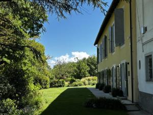 a side view of a building with a grass yard at La Torre Granaia in Serravalle Scrivia