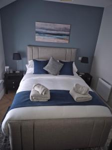 a bedroom with a large bed with towels on it at The Ledger Rooms in Gort