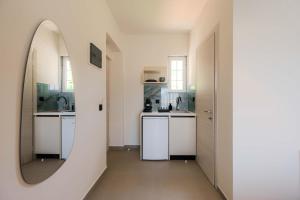 a kitchen with white counters and a mirror at Blue Bay Hotel in Skala Potamias +76 photos