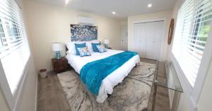 a bedroom with a large bed with blue pillows at Lake View Escape! in West Kelowna