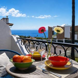 a table with bowls of fruit and wine glasses on a balcony at Oceanview Mesa del Mar in Santa Cruz de Tenerife