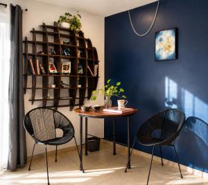 a table and chairs in a room with a blue wall at Suite en el corazón de Arandas in Arandas