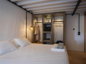 a bedroom with a white bed and a closet at GuestReady - ALMA - Island House in Faial da Terra
