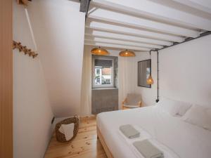 a bedroom with a large white bed and a window at GuestReady - ALMA - Island House in Faial da Terra +91 photos