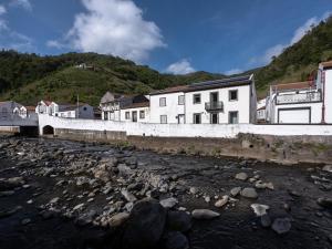 a group of buildings on the side of a river at GuestReady - ALMA - Island House in Faial da Terra