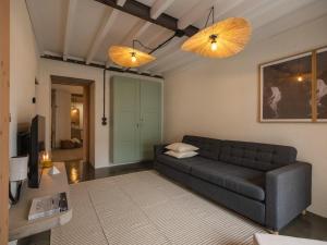 a living room with a black couch and two lights at GuestReady - ALMA - Island House in Faial da Terra