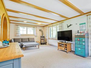 a living room with a couch and a flat screen tv at Sonniges Chalet mit fantastischem Bergblick in Lenk