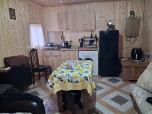 a small kitchen with a table and a refrigerator at Temos cottage in Borjomi