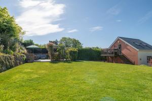 a large yard with a house and a building at Garden View Apartment in Salcombe