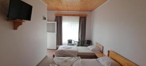 a room with two beds and a flat screen tv at Casa Didi in Vama Veche