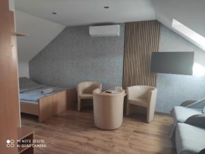 a room with a bed and two chairs and a table at Pokoje Gościnne Leśna 33 in Sława