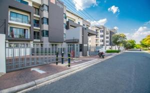 an empty street in front of a building at Modern 2 Bed 1 Bath Apt With Complex Pool in Johannesburg