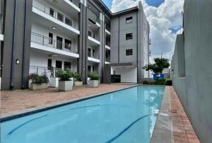 a swimming pool in front of a apartment building at Modern 2 Bed 1 Bath Apt With Complex Pool in Johannesburg