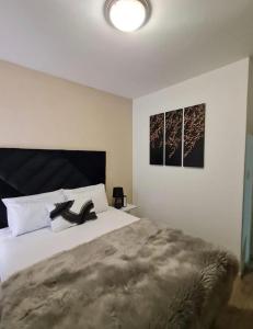 a bedroom with a bed and two pictures on the wall at Modern 2 Bed 1 Bath Apt With Complex Pool in Johannesburg +7 photos