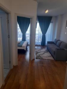a living room with blue curtains and a couch at Apartament Camelia in Saturn