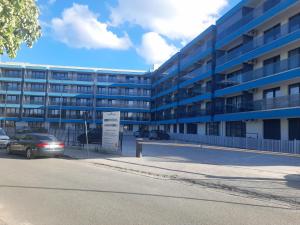 a car parked in front of a large building at Apartament Camelia in Saturn