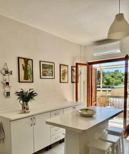 a kitchen with white cabinets and a table at Mare Mio Talamone in Talamone