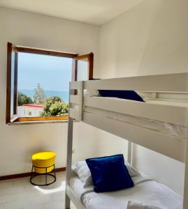 a bunk bed in a room with a window and a yellow stool at Mare Mio Talamone in Talamone