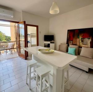 a kitchen and living room with a table and a couch at Mare Mio Talamone in Talamone