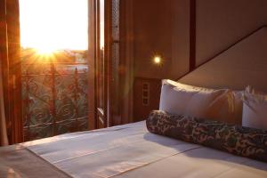 a bedroom with a bed and a window with the sun at Posada San Miguel Arcángel Experience in Arévalo