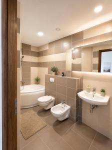 a bathroom with two sinks and a toilet and a tub at ToVa Apartamentai in Šventoji +16 photos