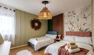 a bedroom with two beds and a chandelier at Big Center Beachfront Apartment in Durrës +35 photos