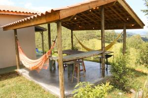a porch with a hammock and a house at Casa Aroni - 1300m altitude in Extrema
