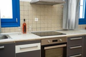 a kitchen with a sink and a stove at Blue Veranda Apartment in Pera Gyalos +39 photos