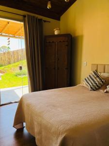 a bedroom with a bed and a large window at Casa Aroni - 1300m altitude in Extrema
