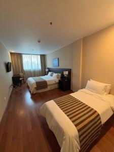 a hotel room with two beds and a window at Amérian Rosario in Rosario
