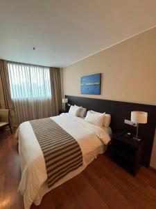 a bedroom with a large bed in a hotel room at Amérian Rosario in Rosario