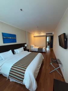 a hotel room with two beds and a flat screen tv at Amérian Rosario in Rosario