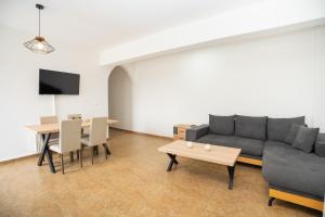 a living room with a couch and a table at Blue Veranda Apartment in Pera Gyalos