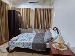 a bedroom with a bed and a table with a lamp at Casa Maria in Sibulan
