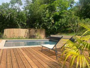 a deck with a chair and a swimming pool at Le Petit Manoir avec Piscine Privée in Le Bugue