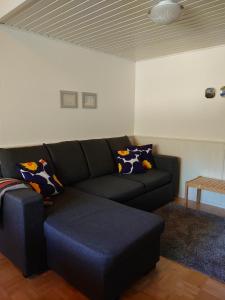a living room with a black couch and a table at Holidayhome RintintinTahko in Tahkovuori +3 photos