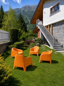 a group of chairs sitting on the grass in front of a building at Villa Rostagno in Entracque