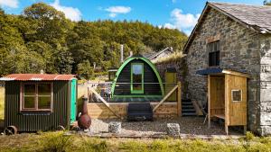 a small green house next to a building at Scenic Pet Friendly Pod in Talybont Aberystwyth in Aberystwyth