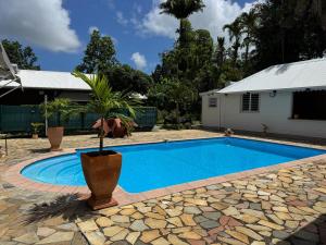 a swimming pool in front of a house at Tropical Lodge in Petit-Bourg