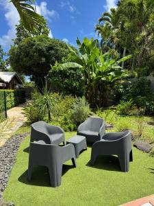 a group of chairs sitting on the grass at Tropical Lodge in Petit-Bourg