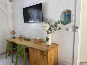 a room with a wooden table with a tv on the wall at Tropical Lodge in Petit-Bourg