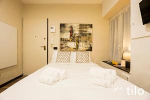 a bedroom with a large white bed with two pillows at City center 4’|Studio|wifi|By tilo in Genoa